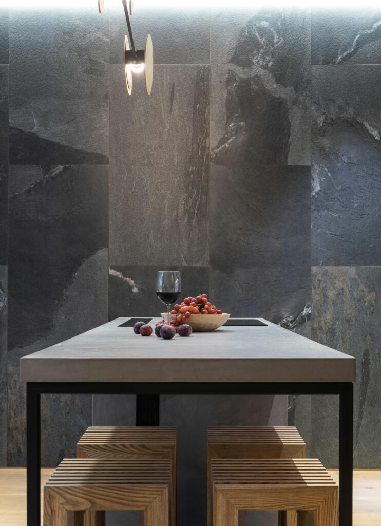 Stylish interior with a table, wine glass, and fruits in a contemporary setting.