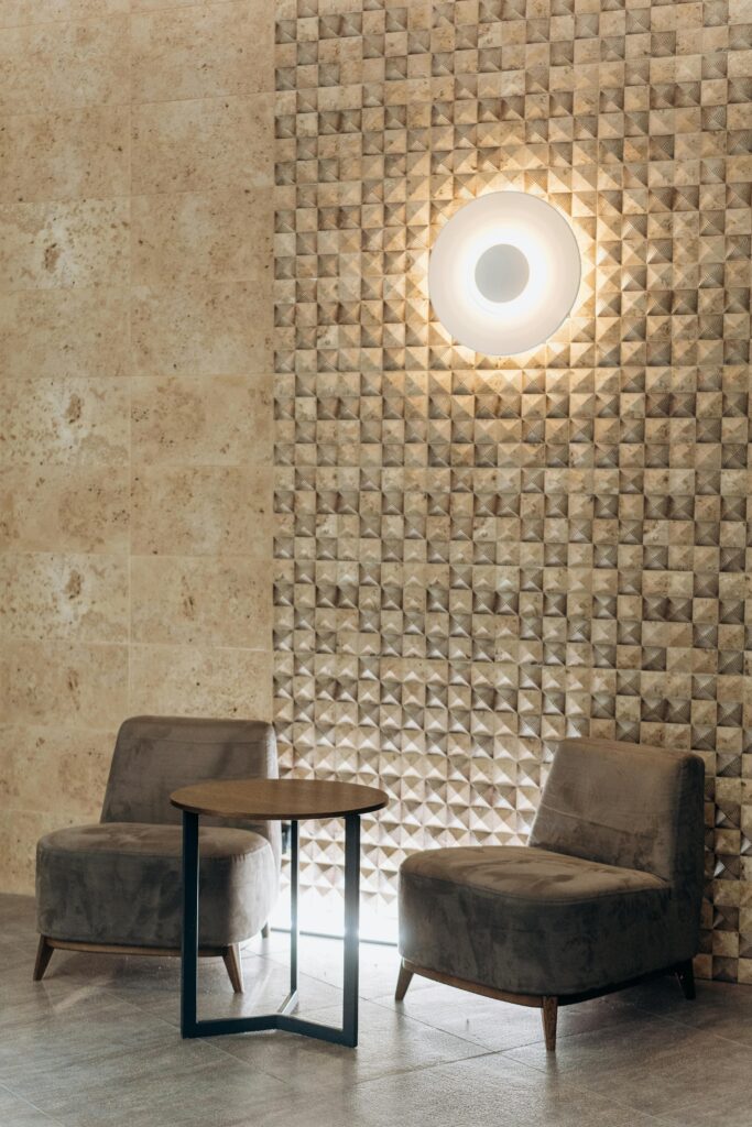 Elegant modern lounge with plush seating and ambient lighting against a textured wall.