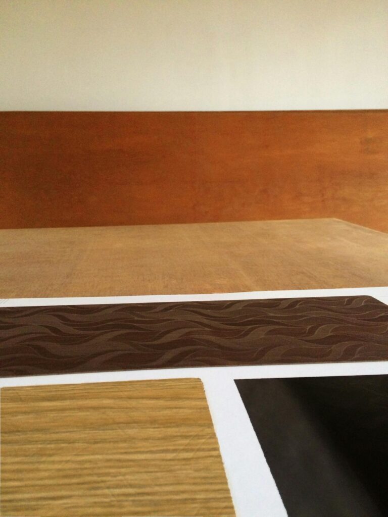 Close-up of various wooden laminate samples showcasing different textures and colors on a wooden table.